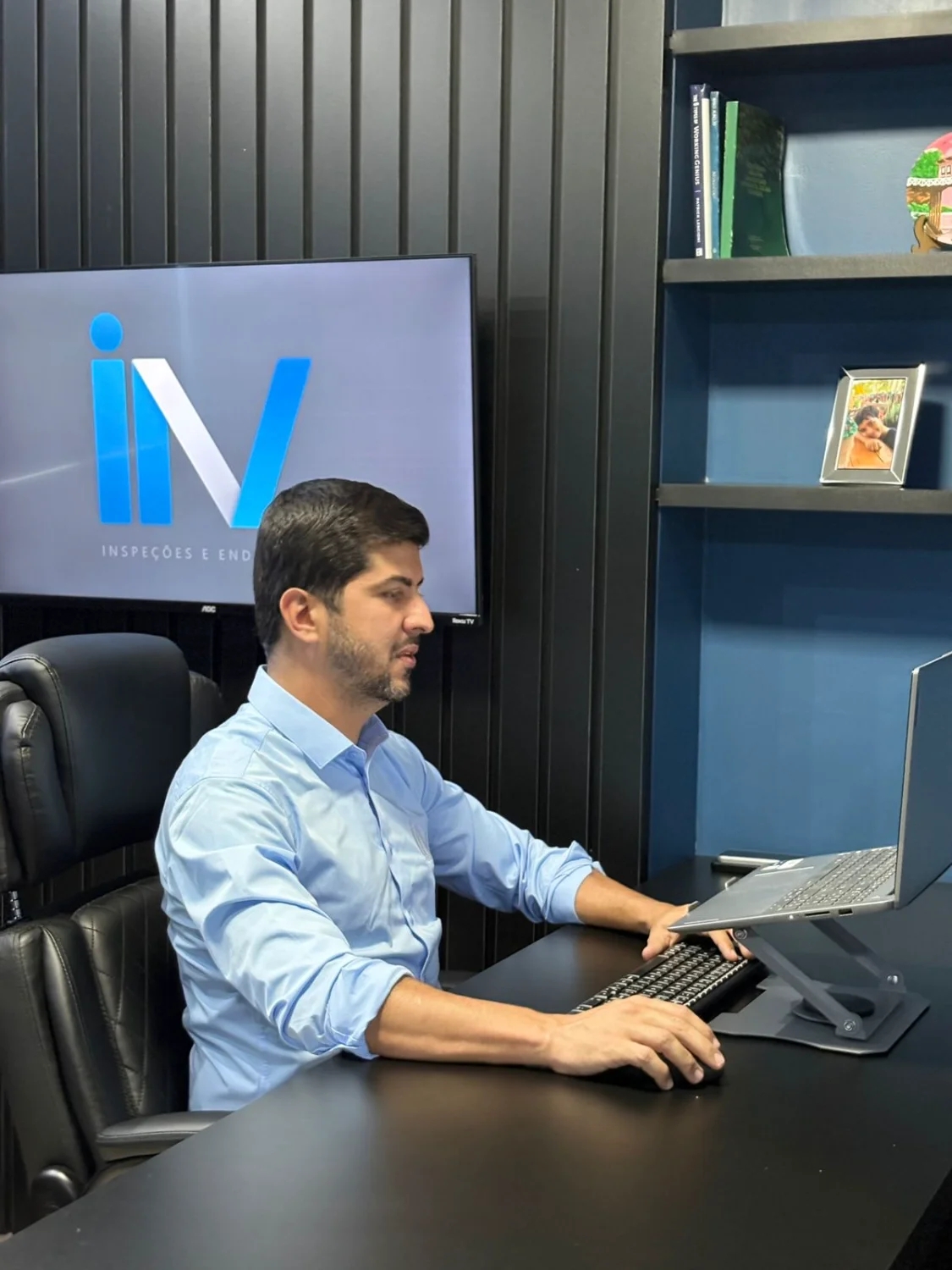 Profissional trabalha no computador em escritório moderno da Microsenior/INV com logo ao fundo