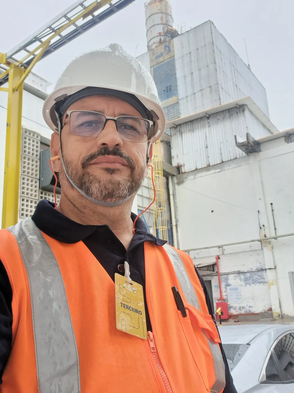 Inspetor da Microsenior/INV com EPIs em frente a uma estrutura industrial, pronto para inspeção